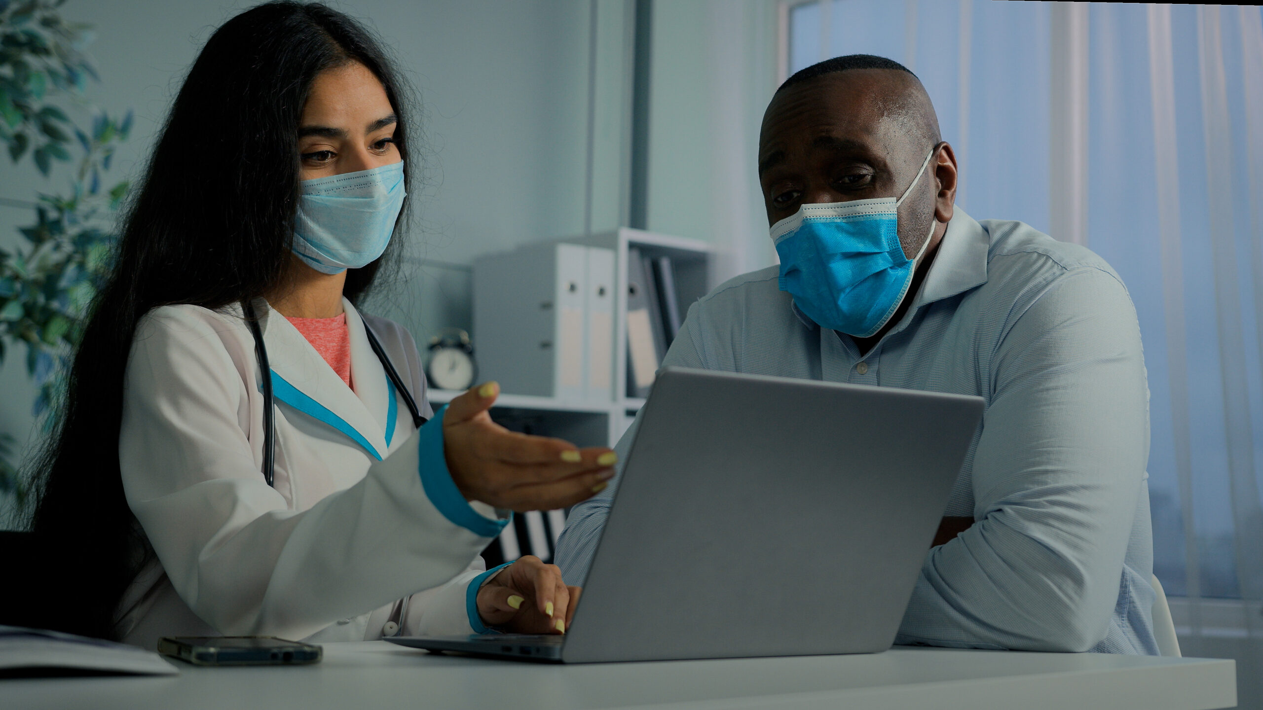 Young doctor woman talk with old man patient in mask use laptop check electronic health test result service online medicine register elderly client on computer modern tech give medical recomendation. High quality 4k footage